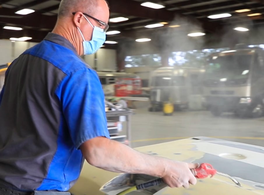 Blowing debris from a fiberglass RV panel.